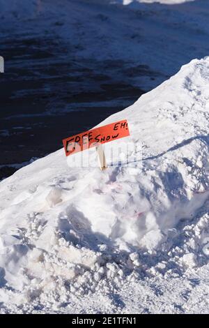 Rimozione della neve con un divertente segno che dà via la neve libera Foto Stock