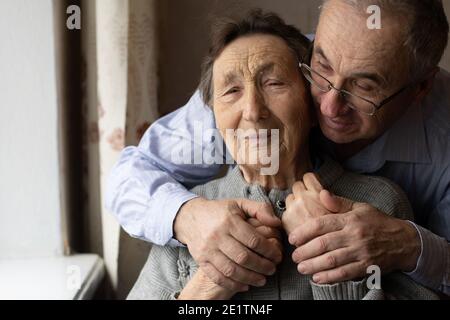 Uomo abbracciando la madre indossando Hijab Foto Stock