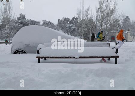 Madrid, Spagna - 09 gennaio 2021: Panca e mobili di strada coperti e completamente sepolti nella neve, in una giornata nevosa, a causa del freddo polare filomena Foto Stock