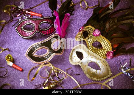 Assortimento di maschere di carnevale veneziane su sfondo viola. Concetto di mardi gras maschera o mascheramento, festa di Capodanno Foto Stock