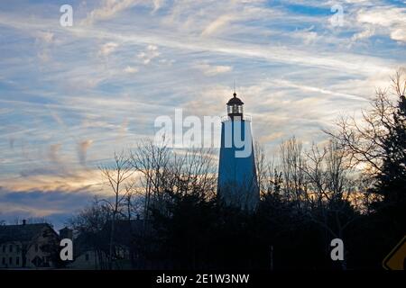 Faro di Sandy Hook silhouette contro un cielo parzialmente nuvoloso a. tramonto -32 Foto Stock