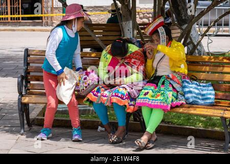 Le donne locali controllano i loro telefoni cellulari a Urubamba nel distretto di Cusco, Perù Foto Stock