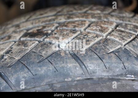 Chiodo per pneumatici auto annegato nel pneumatico rotto, avvitare il pneumatico nero. Problemi e soluzioni degli pneumatici danneggiati. Foto Stock