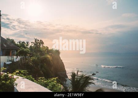 una costa dall'oceano pacifico con palme e molto altro alberi facendo surf nelle onde Foto Stock