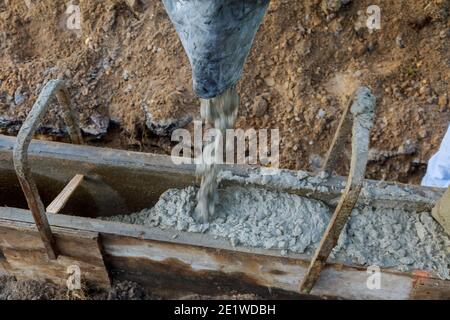 Appaltatore di costruzioni in calcestruzzo che installa un marciapiede, marciapiede su un nuovo progetto urbano stradale Foto Stock