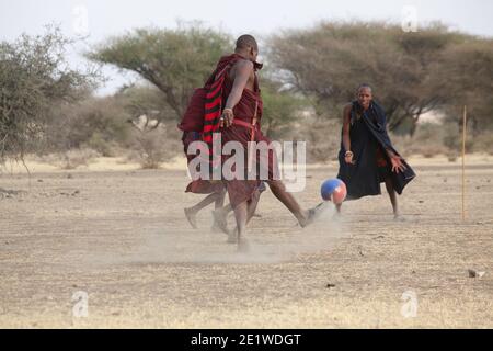 I giovani Masai Warriors giocano a calcio nella savana Foto Stock