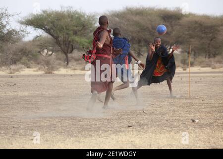 I giovani Masai Warriors giocano a calcio nella savana Foto Stock