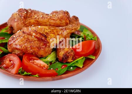 Briciola di pollo piccante al forno con insalata su sfondo bianco. Primo piano. Foto Stock