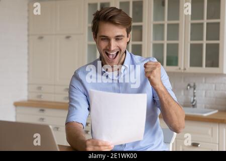 L'uomo eccitato si sente euforico con buone notizie in lettera Foto Stock