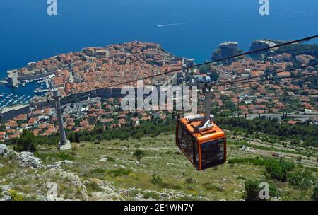 La funivia di Dubrovnik porta i turisti dalla città vecchia alla cima del Monte SRD. Mura della città vecchia e il mare Adriatico sullo sfondo. Foto Stock