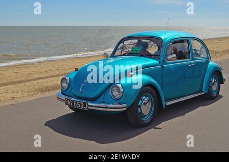 Classico blu VW Beetle essendo guidato lungo il lungomare Felixstowe. Foto Stock