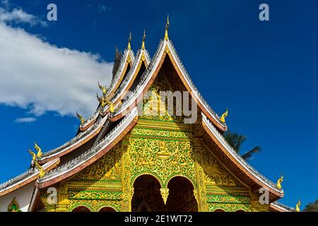 Tetto multilivello in stile thailandese adornato con finals stilizzate di Naga alle estremità del tetto, tempio di Haw Pha Bang, Luang Prabang, Laos Foto Stock