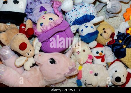 diversi tipi di peluche morbidi giocattoli sul pavimento ovunque in una camera per bambini Foto Stock