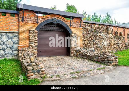 Imponente cancello automatico in grande muro di pietra Foto Stock