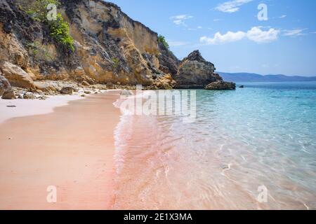 Onde morbide che si infrangono sulla remota spiaggia rosa di Komodo Parco Nazionale in Indonesia Foto Stock