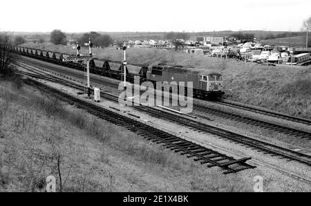 La locomotiva diesel di classe 56 No.56069 dirige un treno di carbone MGR alla centrale elettrica di Didcot a Fenny Compton, Warwickshire, Regno Unito. 1987 Foto Stock