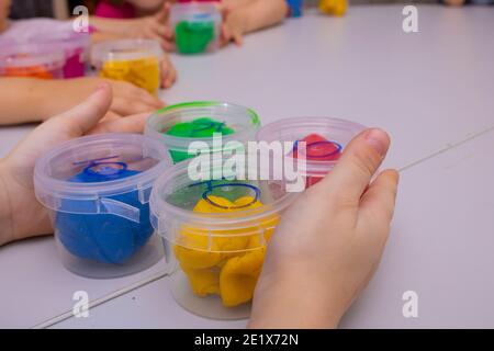 Le mani del bambino giocano con argilla colorata, abilità sensoriali Foto Stock