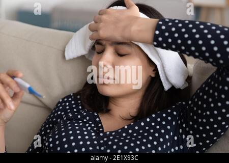 Giovane donna asiatica coreana malsana che misura la temperatura corporea. Foto Stock