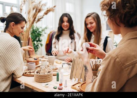 Quattro donne in negozio ecologico selezionando e discutendo vari cosmetici prodotti Foto Stock