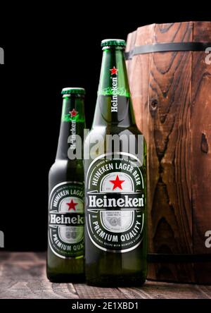LONDRA, UK - 27 APRILE 2018: Bottiglie di birra Heineken Lager accanto al barile di legno. Heineken è il prodotto di punta di Heineken International Foto Stock