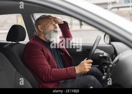 Scioccato uomo d'affari senior che ha problemi sulla strada, seduto in auto Foto Stock