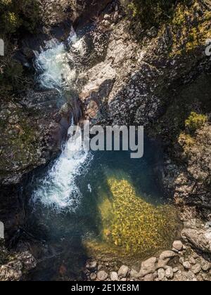 Vista aerea di un torrente di montagna che si trasforma in un chiaro Piscina a Pirio in Corsica Foto Stock