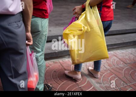 Per trasportare oggetti da un negozio sono state utilizzate coloratissime borse di plastica monouso. Foto Stock