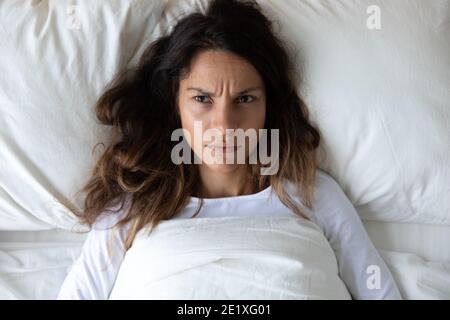 Vista dall'alto infelice infastidita donna sdraiata a letto, concetto di insonnia Foto Stock