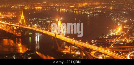 Vista aerea dei ponti sospesi di Bhumibol e delle autostrade che si snodano sul fiume Chao Phraya al crepuscolo. Foto Stock