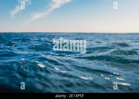 Onde blu in oceano. Consistenza d'acqua con bokeh Foto Stock