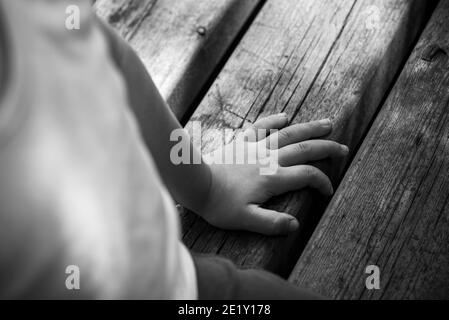 La mano sporca del bambino sul legno Foto Stock