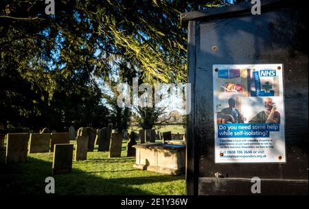 Aiuto di N.H.S. durante l'auto-isolamento poster su una bacheca chiesa con cantiere. Foto Stock