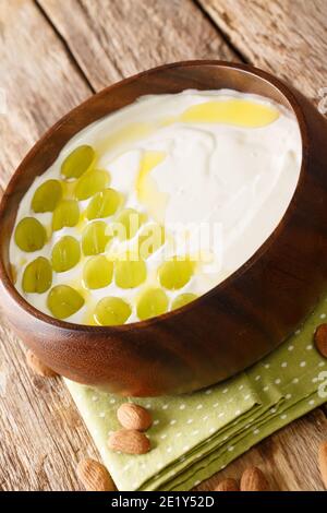 L'Ajo blanco è una deliziosa zuppa di mandorle fredde e aglio tipica dello spicchio della Spagna meridionale nel piatto. Verticale Foto Stock