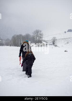 Due persone che camminano attraverso la neve Foto Stock