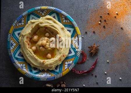 Vista dall'alto della piastra dell'ummus. Cibo mediorientale. Concetto di alimentazione sana. Sfondo grigio con spazio per la copia. Foto Stock