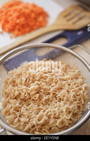 bollire immediatamente il noodle sul setaccio in acciaio inossidabile dopo lo scarico Foto Stock