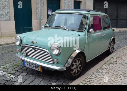 Classica auto Austin Mini azzurra per le strade del quartiere Alfama di Lisbona, Portogallo. Foto Stock