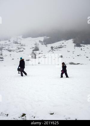 Due persone che camminano attraverso la neve Foto Stock