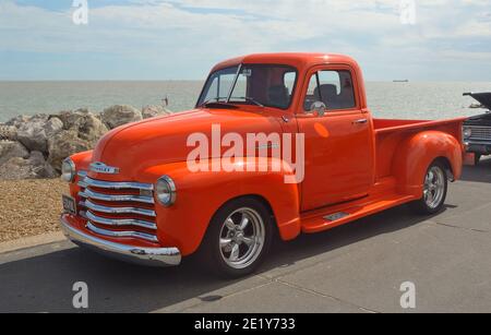 Classico pick-up Orange Chevrolet luminoso sul lungomare di Felixstowe. Foto Stock