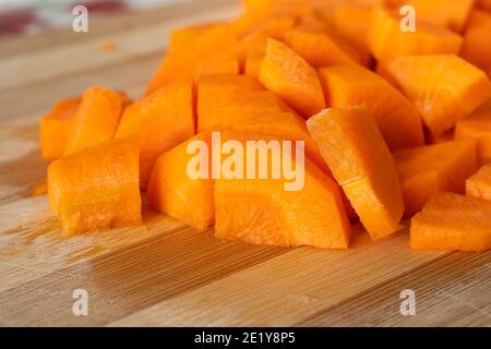 Un mucchio di carote fresche tagliate su tavola legnosa. Cibo Foto Stock