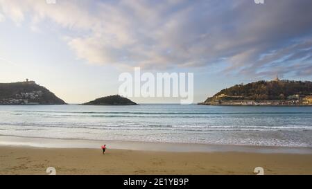 2020 02, Donostia, Spagna. Surfer che lascia la spiaggia di Concha in inverno. Foto Stock