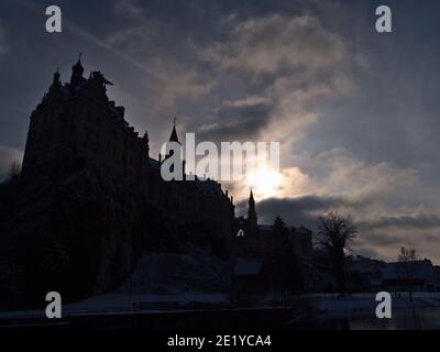 Silhouette scura dello storico Castello di Hohenzollern a Sigmaringen, Alb Svevo, Germania, sulle rive del Danubio nella stagione invernale con il sole luminoso. Foto Stock