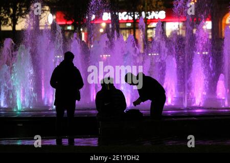 Le persone si siedono intorno alle fontane dei Piccadilly Gardens di Manchester. Foto Stock