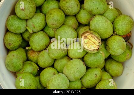 Noci fresche con buccia verde. Fresco raccolto, crudo, delizioso e naturale cibo. Vista dall'alto, disposizione piatta. Spuntini salutari. Foto Stock