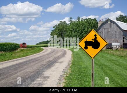 Farm Equipment Caution Sign: Un cartello nel Wisconsin meridionale avvisa gli automobilisti di guardare per i macchinari agricoli sulla strada che precede. Foto Stock
