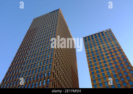 Alti edifici fotografati dal basso sull'Amsterdam Zuidas in una giornata di sole con un cielo blu e leggermente nuvoloso. Foto Stock