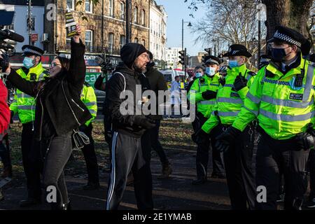 Gli agenti di polizia si sono scontrati con alcuni dei manifestanti privi di mascherine che sono arrivati a Clapham Common, alcuni gridando 'take your libert back'. Foto Stock