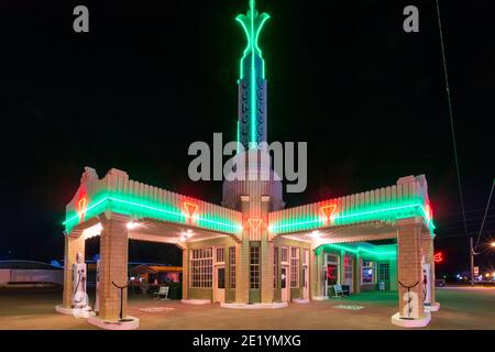 Torreggianti luci al neon presso la storica stazione di servizio Conoco sulla Storica Route 55 a Shamrock, Texas Foto Stock