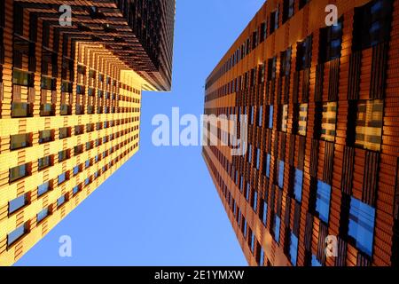 Alti edifici fotografati dal basso sull'Amsterdam Zuidas in una giornata di sole con un cielo blu e leggermente nuvoloso. Foto Stock