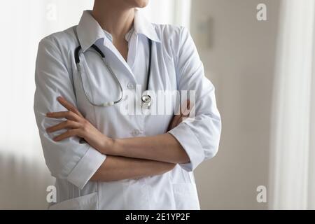 Immagine ritagliata di una lavoratrice medica femminile in piedi con le braccia ripiegate. Foto Stock